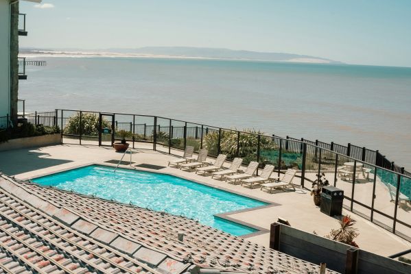 Relaxing poolside view overlooking the ocean at a Pismo Beach resort, ideal for a serene vacation.